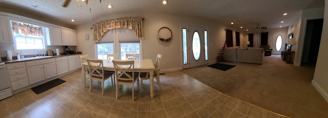 carpeted dining space featuring ceiling fan and sink