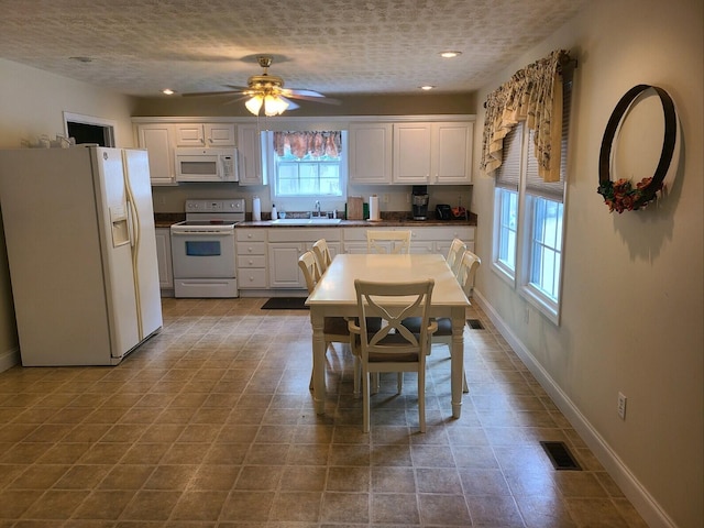 kitchen with white appliances, white cabinets, sink, ceiling fan, and a textured ceiling