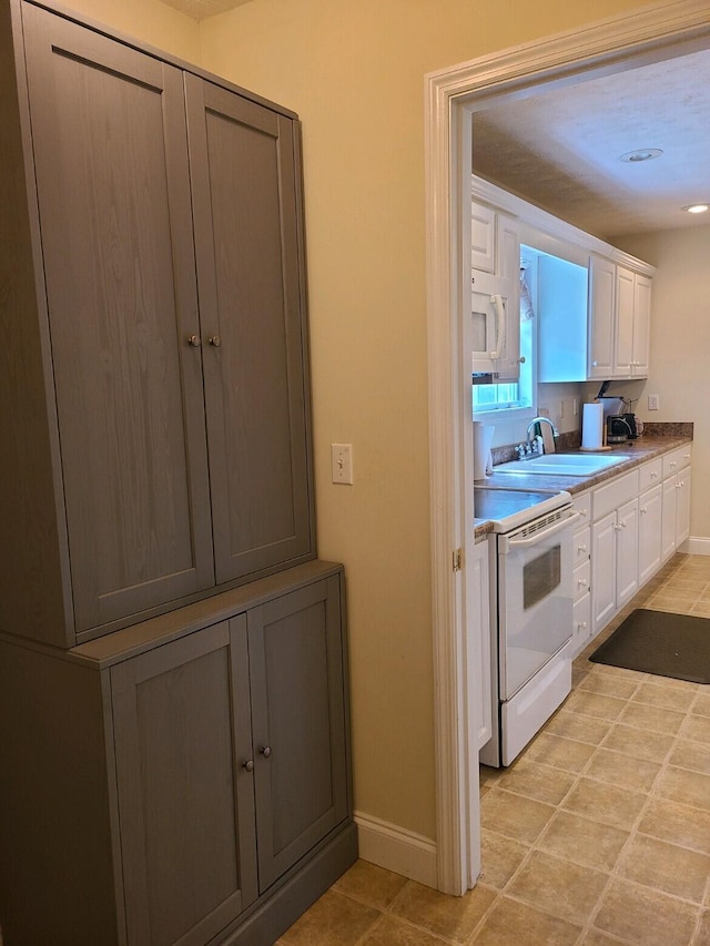 kitchen with sink, white cabinets, and white appliances