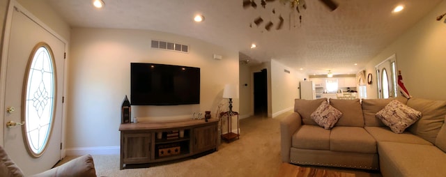 carpeted living room with ceiling fan and lofted ceiling