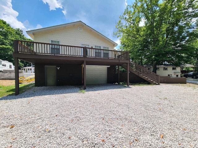 back of house featuring a garage and a deck