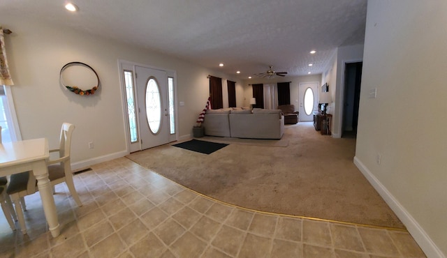 carpeted foyer with ceiling fan