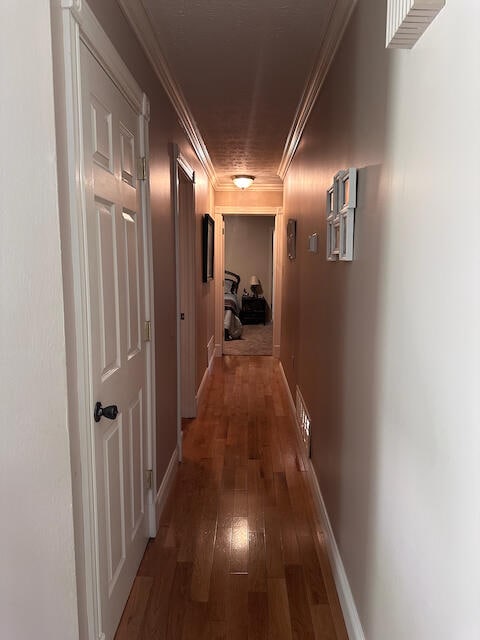 corridor featuring ornamental molding and hardwood / wood-style floors