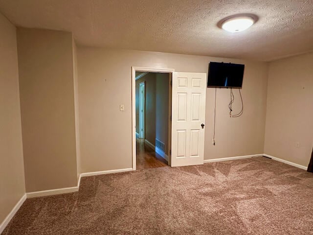 unfurnished room with carpet floors and a textured ceiling