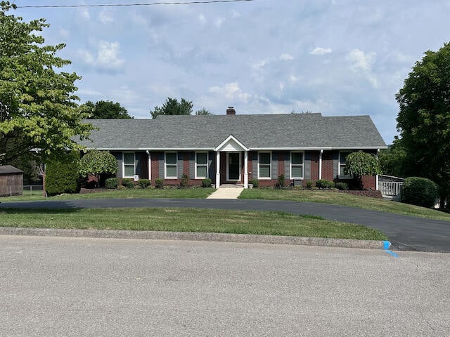 single story home featuring a front lawn