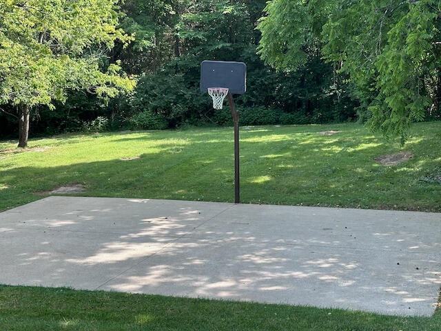 view of basketball court with a yard