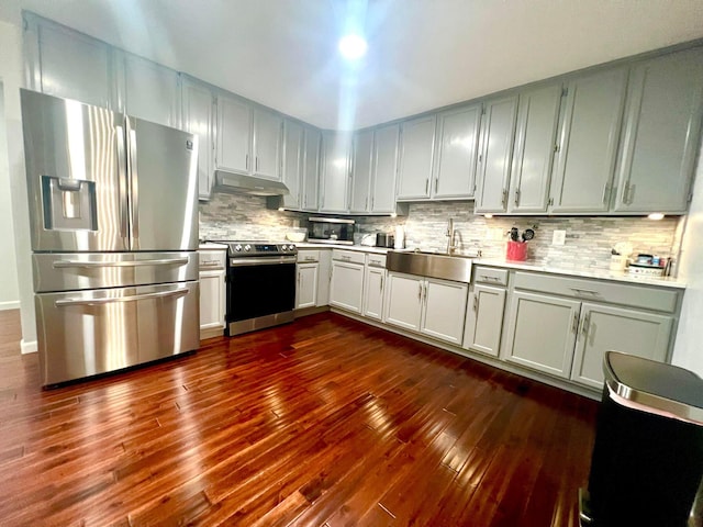 kitchen with decorative backsplash, dark hardwood / wood-style flooring, sink, and appliances with stainless steel finishes