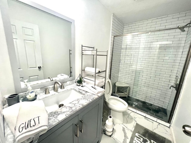 bathroom featuring vanity, toilet, a shower with shower door, and a textured ceiling