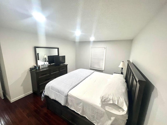 bedroom with a textured ceiling and dark hardwood / wood-style floors