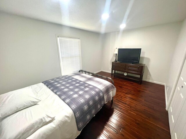 bedroom with dark hardwood / wood-style flooring