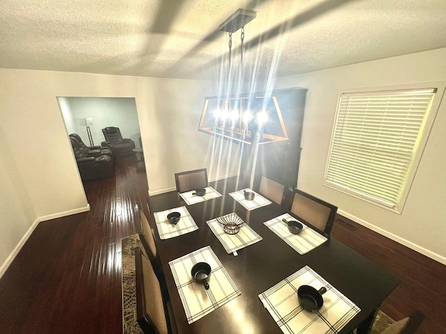 dining room with hardwood / wood-style floors and a textured ceiling