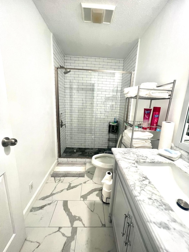 bathroom featuring a textured ceiling, vanity, toilet, and tiled shower