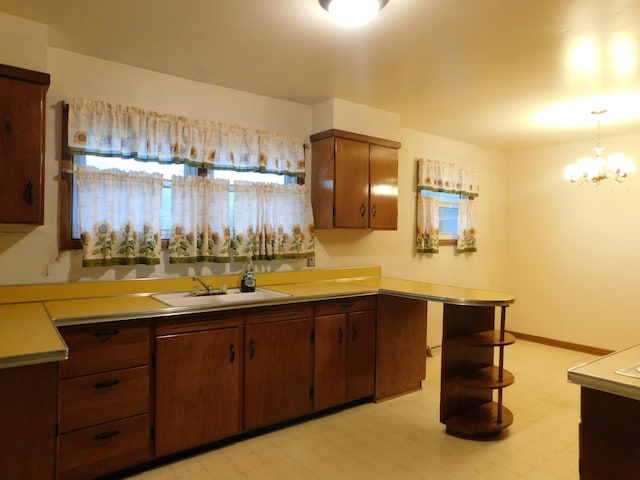 kitchen featuring light floors, a sink, light countertops, and an inviting chandelier