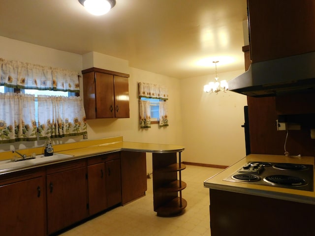 kitchen featuring light floors, electric cooktop, an inviting chandelier, a sink, and exhaust hood