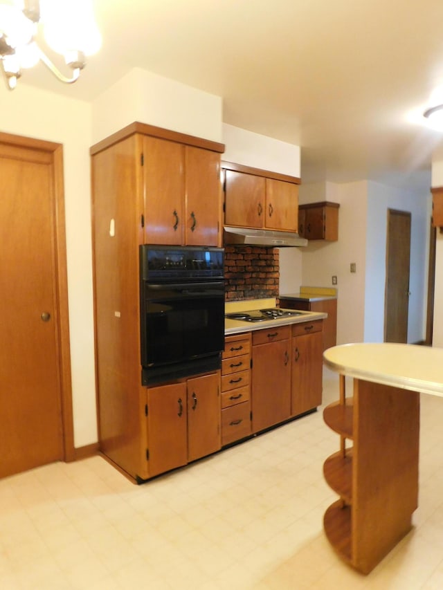 kitchen featuring white electric stovetop, brown cabinetry, oven, under cabinet range hood, and backsplash