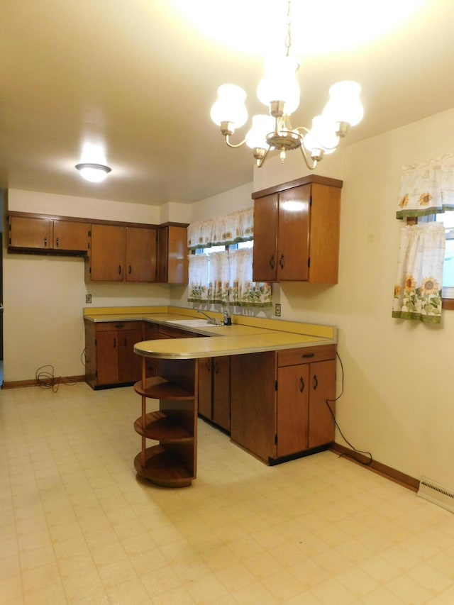 kitchen featuring a notable chandelier, open shelves, light countertops, a peninsula, and baseboards