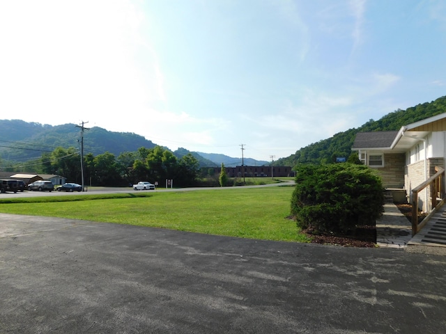 surrounding community with a mountain view and a yard