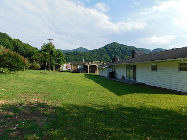 view of yard featuring a mountain view and central air condition unit