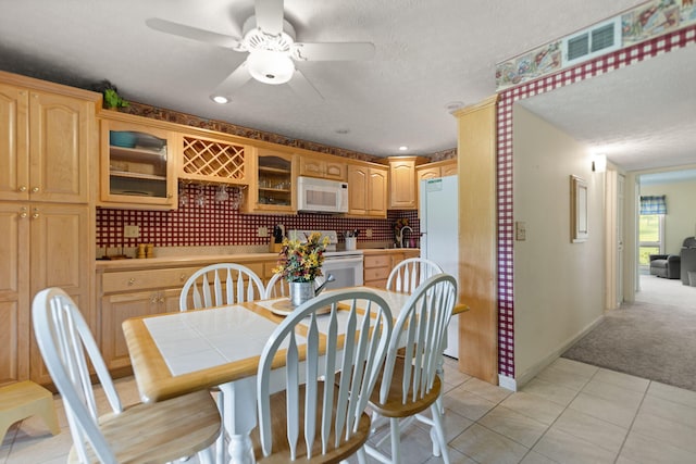 carpeted dining room featuring a textured ceiling and ceiling fan