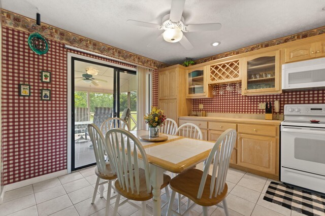 tiled dining room featuring a textured ceiling and ceiling fan