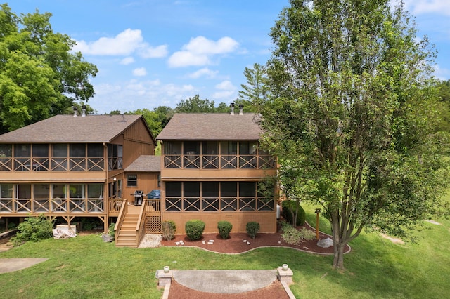 rear view of property with a sunroom and a lawn