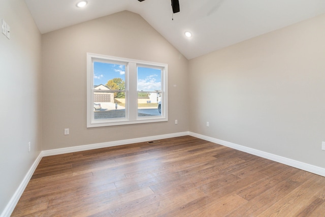 unfurnished room featuring lofted ceiling, hardwood / wood-style floors, and ceiling fan