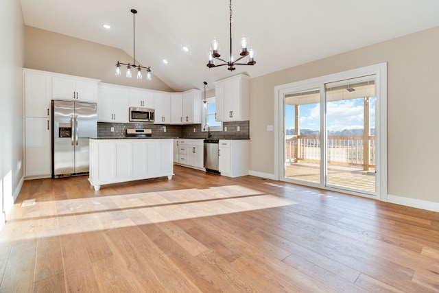 kitchen with white cabinetry, light hardwood / wood-style floors, stainless steel appliances, and pendant lighting