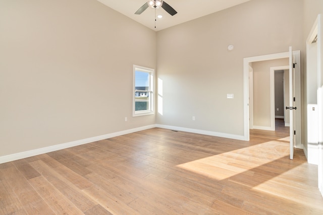 unfurnished room featuring light hardwood / wood-style flooring, high vaulted ceiling, and ceiling fan