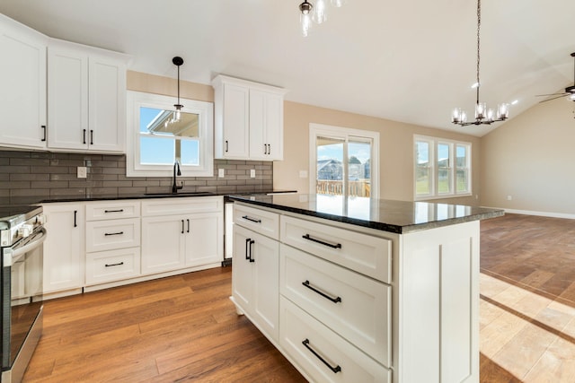 kitchen featuring sink, electric range, white cabinets, light hardwood / wood-style floors, and tasteful backsplash