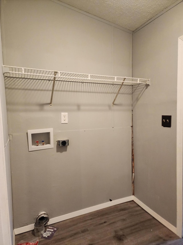 clothes washing area with electric dryer hookup, hookup for a washing machine, a textured ceiling, and dark hardwood / wood-style floors