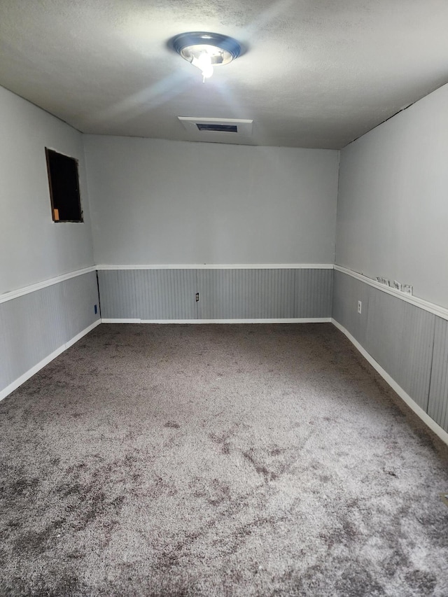 carpeted spare room with a textured ceiling