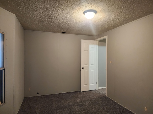 carpeted empty room with a textured ceiling