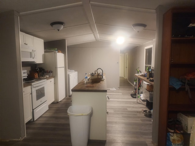 kitchen featuring white appliances, dark wood-type flooring, a center island, white cabinetry, and lofted ceiling