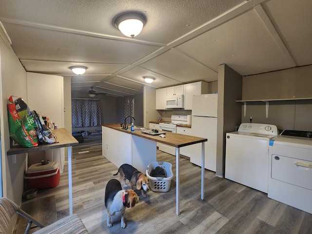 clothes washing area featuring washer and dryer, a textured ceiling, hardwood / wood-style flooring, and ceiling fan