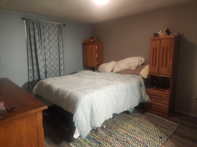 bedroom with dark hardwood / wood-style flooring