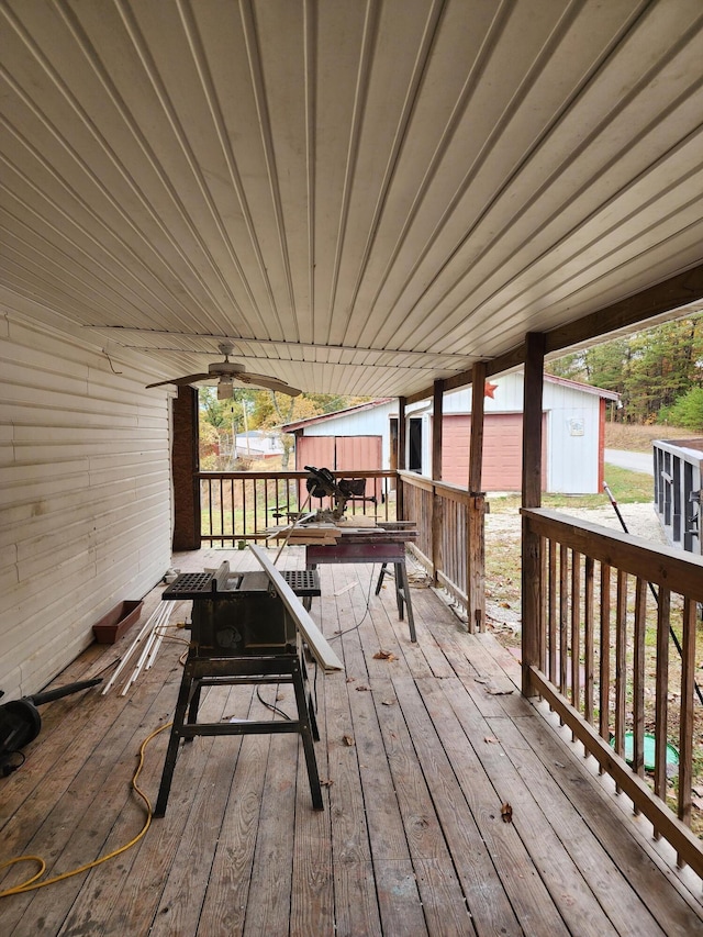 wooden terrace with ceiling fan and an outdoor structure