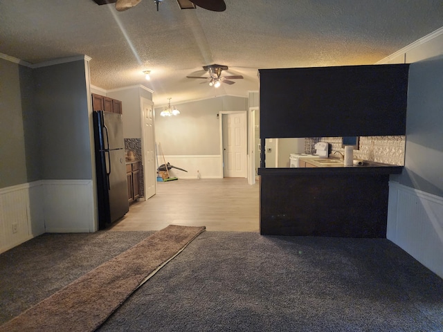 interior space with ornamental molding, a textured ceiling, a notable chandelier, washer / clothes dryer, and stainless steel refrigerator