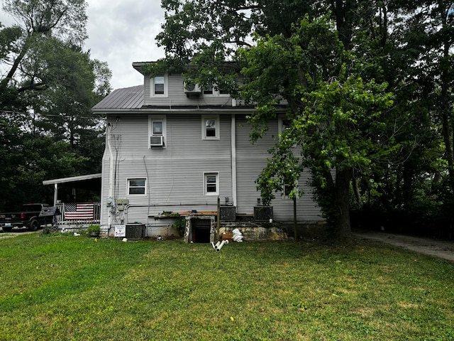 back of property with cooling unit, central air condition unit, and a yard