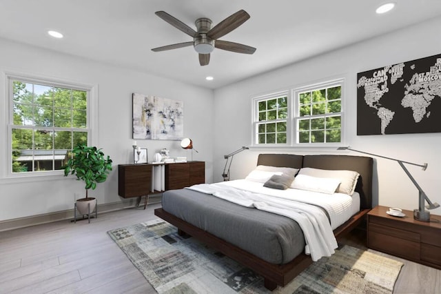 bedroom featuring multiple windows, ceiling fan, and hardwood / wood-style flooring