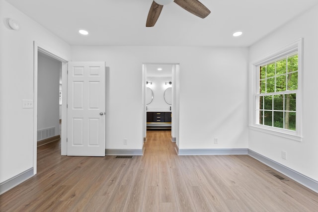 unfurnished bedroom featuring ensuite bathroom, light hardwood / wood-style flooring, and ceiling fan