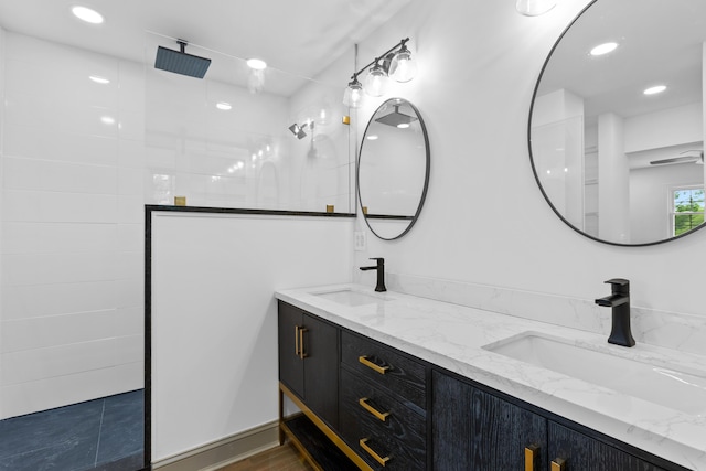 bathroom featuring a tile shower and vanity