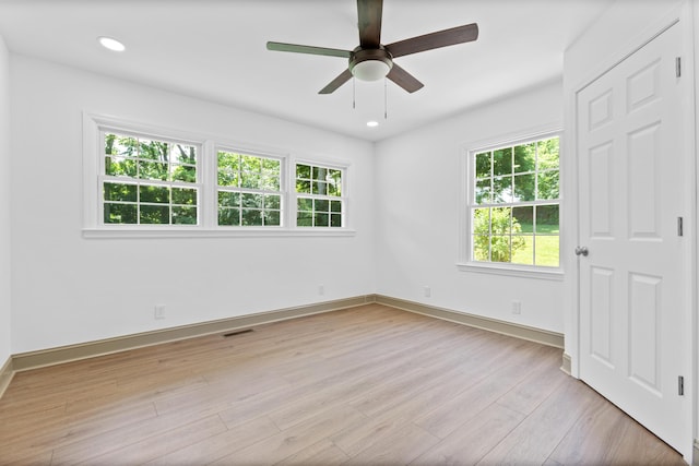 unfurnished room with light hardwood / wood-style floors, ceiling fan, and a healthy amount of sunlight