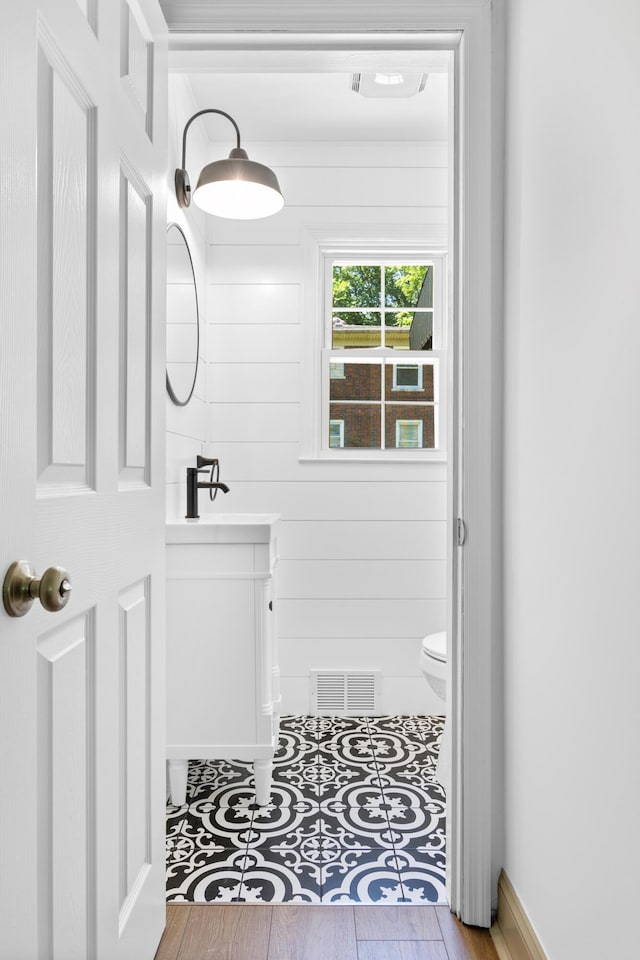 bathroom with hardwood / wood-style floors, vanity, and toilet