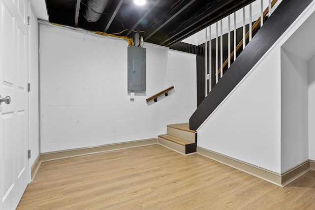 basement with electric panel and hardwood / wood-style flooring