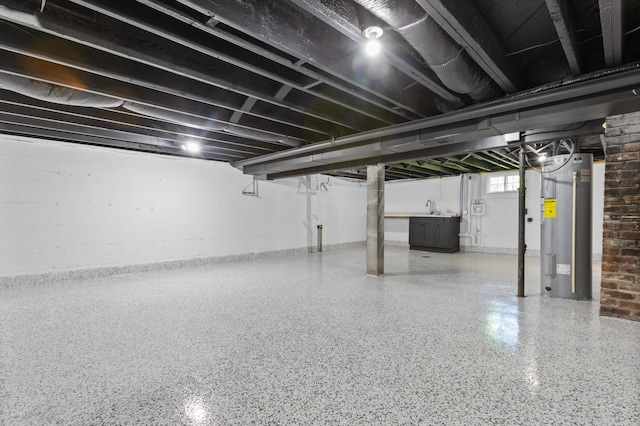 basement featuring electric water heater and sink