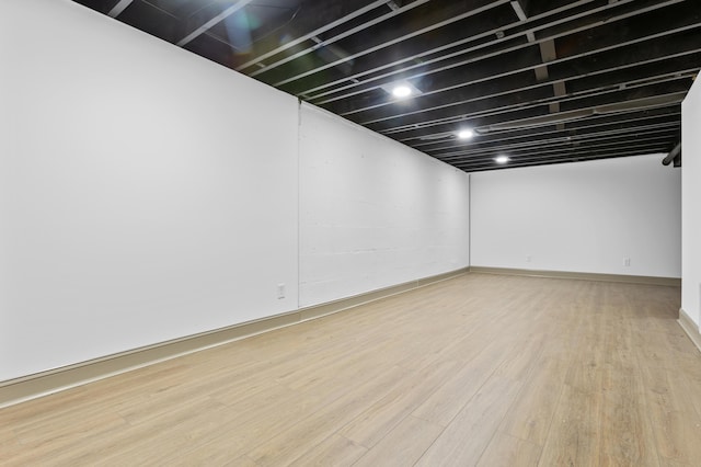 basement with light hardwood / wood-style flooring