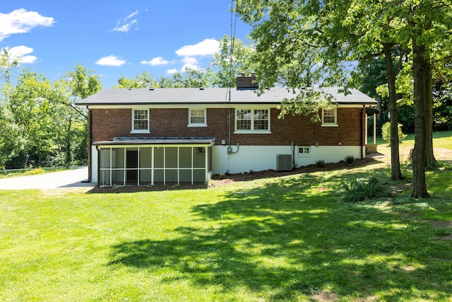 back of property with central AC, a sunroom, and a yard