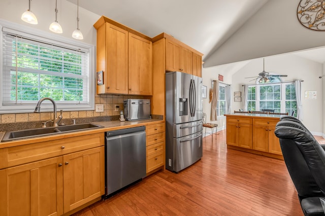 kitchen featuring backsplash, sink, ceiling fan, decorative light fixtures, and stainless steel appliances