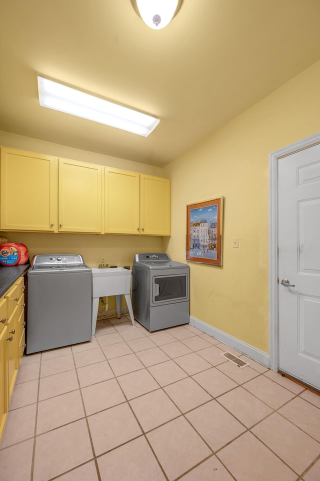 laundry room with cabinets, light tile patterned floors, sink, and washing machine and clothes dryer