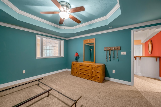 bedroom with carpet, ceiling fan, crown molding, and a tray ceiling